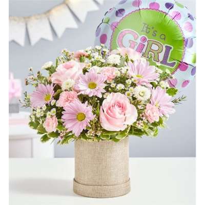 Pink and white flower arrangement in a burlap box with a girl balloon