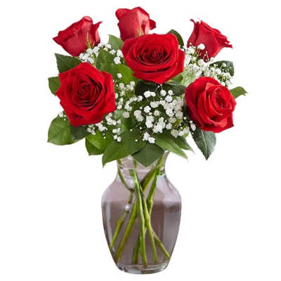 Red roses with baby's breath in a clear glass vase