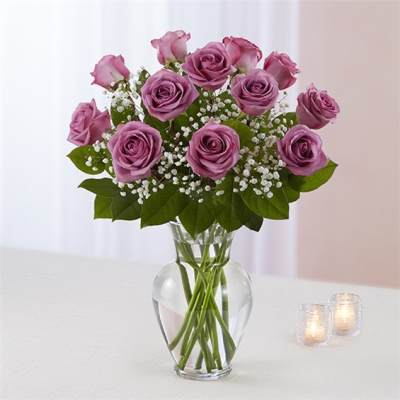 Pink roses in a clear glass vase with baby's breath