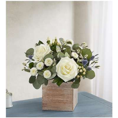 White roses and small white blooms in a wooden box