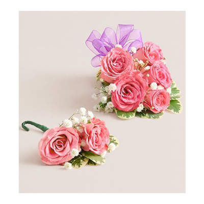 Pink rose corsage and boutonniere with purple ribbon and white filler flowers