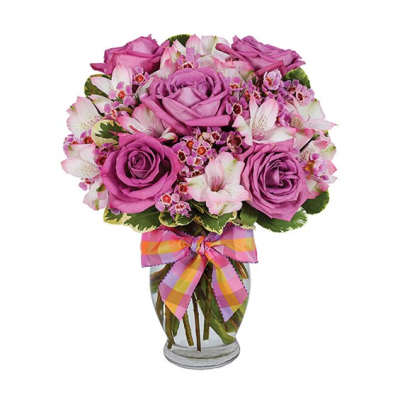 Pink roses and white alstroemeria in a glass vase with a plaid ribbon