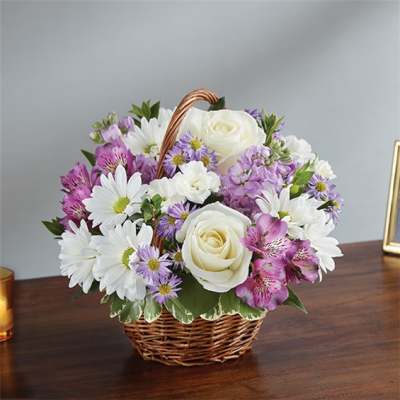 Basket arrangement of white roses, daisies, and purple flowers