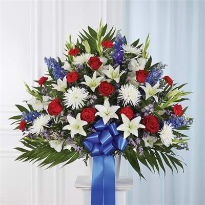 Large bouquet of red roses, white lilies, and blue flowers with a blue ribbon
