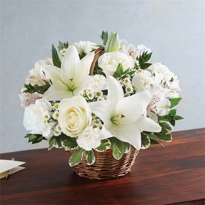 White lilies and roses in a wicker basket