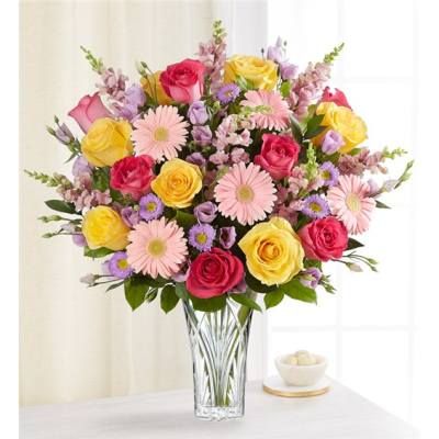 Mixed bouquet of roses and daisies in a clear glass vase