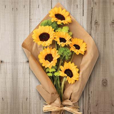 Bouquet of yellow sunflowers wrapped in brown paper
