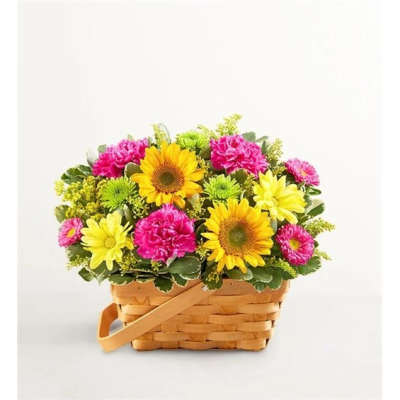 Basket of yellow sunflowers, pink carnations, and daisies
