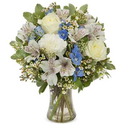 Bouquet of white roses, blue flowers, and striped alstroemeria in a glass vase