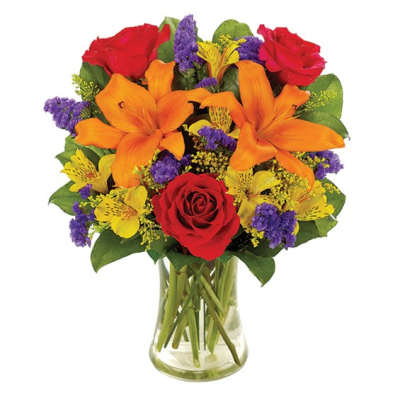 Bouquet of red roses, orange lilies, and purple filler in a clear glass vase