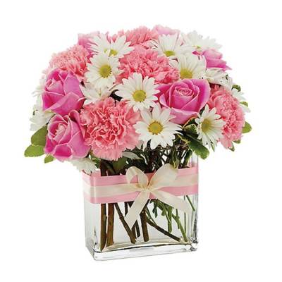 Pink roses, carnations, and white daisies in a glass vase with a ribbon