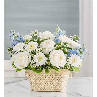 White roses and daisies with blue flowers in a decorative metal container