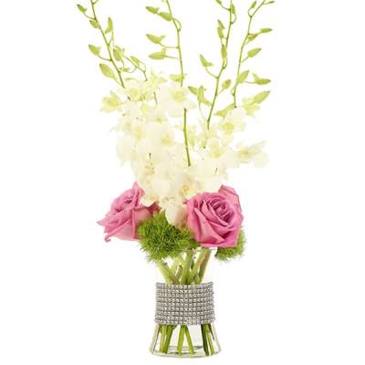 Pink roses and white orchids in a clear vase with a rhinestone wrap