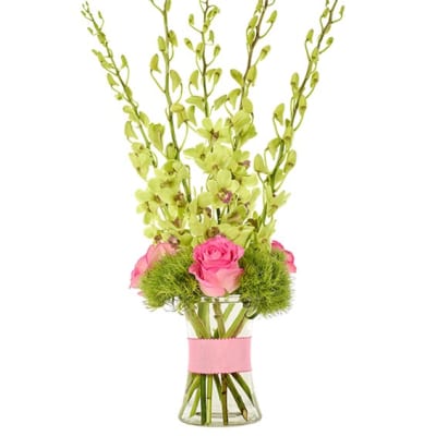 Pink roses in a clear glass vase with tall green stems and lime accents