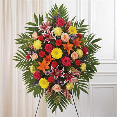 Large standing floral spray with roses, lilies, and daisies on an easel