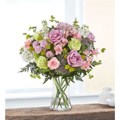 Bouquet of pink and lavender roses in a clear glass vase