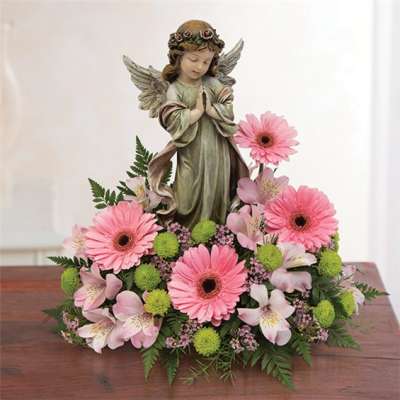 Pink gerbera daisies and alstroemeria around an angel figurine