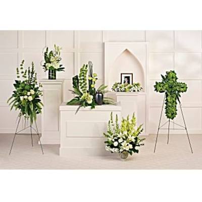 White floral funeral arrangements on pedestals and stands
