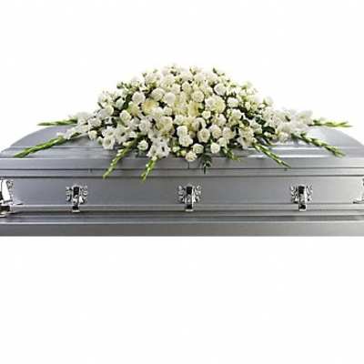 White floral casket spray on a silver casket