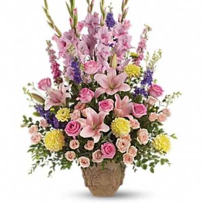 Tall mixed bouquet of pink lilies, roses, and purple flowers in a woven basket