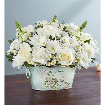 White roses and daisies arranged in a decorative metal container