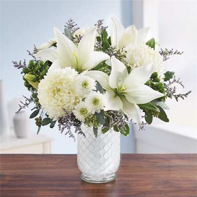 White lilies and chrysanthemums in a textured glass vase