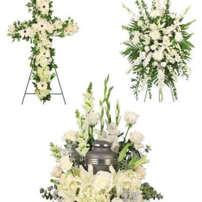 White funeral floral tributes including a cross, spray, and urn arrangement