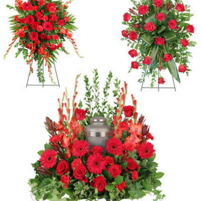 Red floral funeral tribute with a silver urn centerpiece and standing sprays
