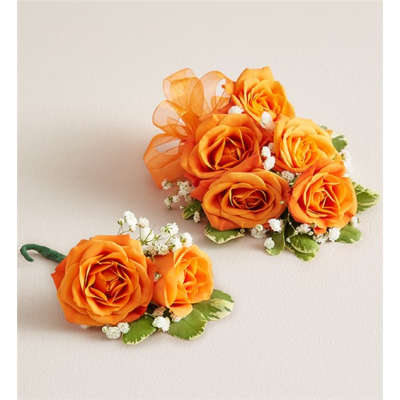 Orange rose corsages with small white filler flowers and green leaves
