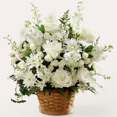 White roses and daisies arranged in a woven basket