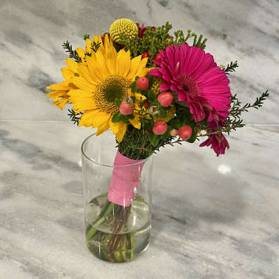 Bouquet of yellow and pink gerbera daisies in a clear glass vase