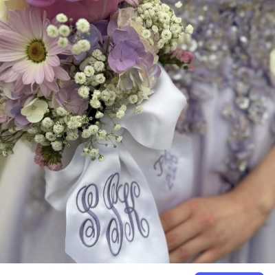 Pastel bouquet with a pink rose, daisy, and baby’s breath tied with a white ribbon