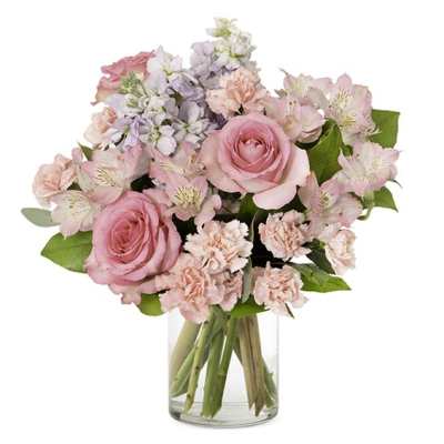 Pink roses and pastel flowers arranged in a clear glass vase