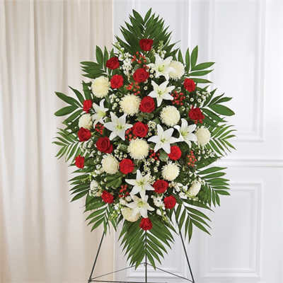 Standing floral spray with red roses, white lilies, and white pompons