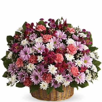 Mixed pink, purple, and white flowers in a wicker basket