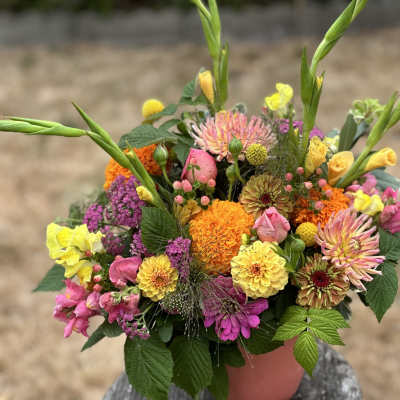 Colorful mixed bouquet in a pink container with tall green stems