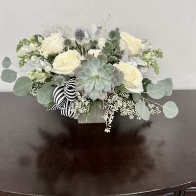 White rose arrangement with a succulent in a low square container