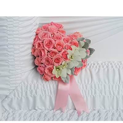 Pink rose bouquet with pale flowers and a pink ribbon on white bedding