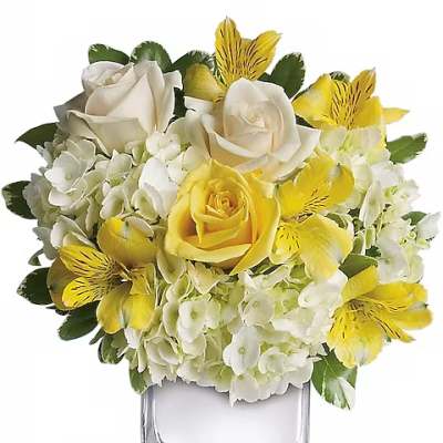 Yellow and white floral arrangement in a clear square vase