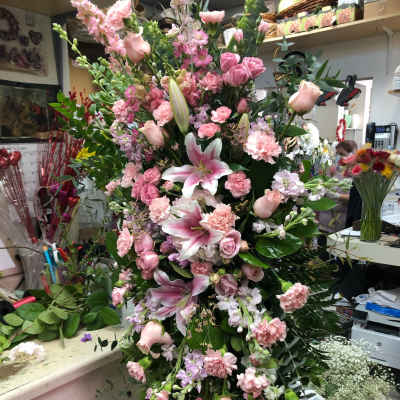 Tall pink floral spray with lilies, roses, and carnations