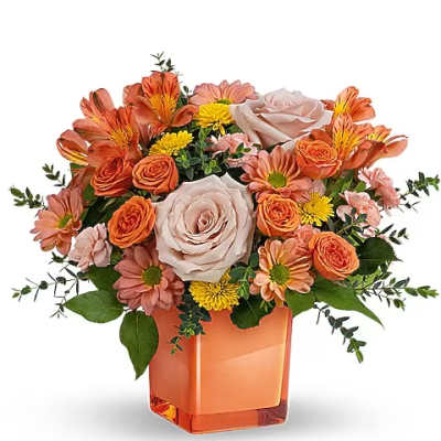 Orange and blush bouquet in a square orange vase