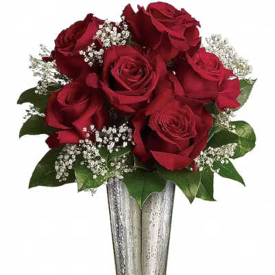 Red roses arranged in a tall silver vase with white filler flowers