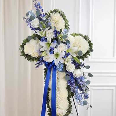 White and blue funeral standing spray with a ribbon on a stand