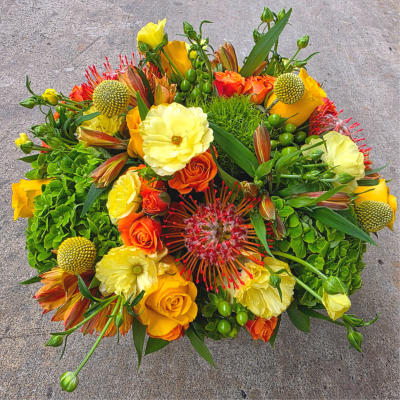 Bright bouquet of yellow, orange, and red flowers with green accents