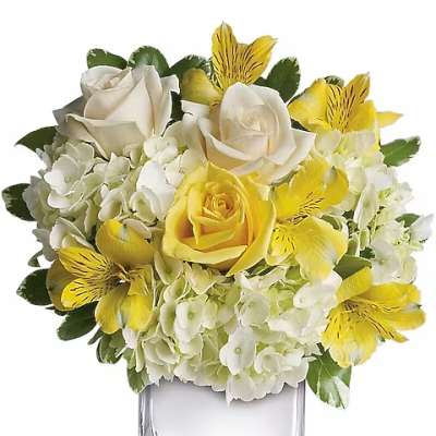 Yellow and white flower arrangement in a clear square vase
