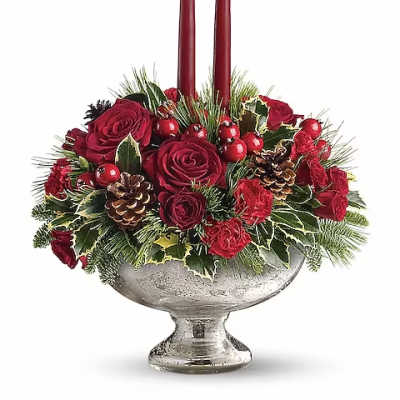 Red rose arrangement with two tall candles in a silver pedestal bowl