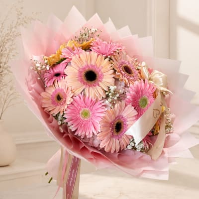 Pink and peach gerbera daisy bouquet wrapped in pastel paper