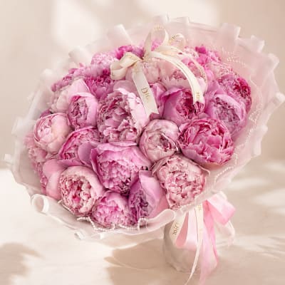 Pink peony bouquet wrapped in sheer paper with ribbon