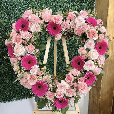 Heart-shaped floral wreath with pink roses and bright gerbera daisies
