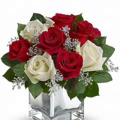 Red and white roses arranged in a clear square vase